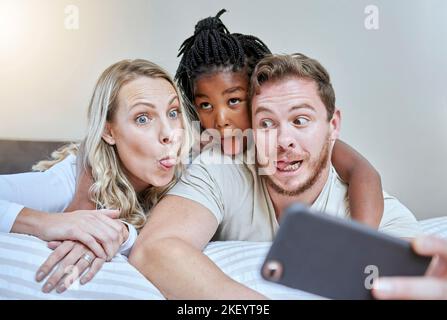 Enfant, parents ou visage comique pour téléphone selfie dans la maison, l'hôtel ou la chambre à la maison sur les médias sociaux, la mémoire vlog ou le plaisir. Mère, père ou fille noire Banque D'Images