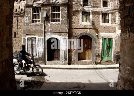 Un motocycliste dans la ruelle de la vieille ville, Sana’a, Yémen Banque D'Images