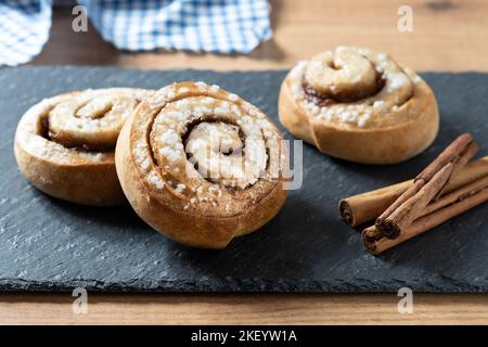 Petits pains à la cannelle sur une table en bois. Dessert suédois Kanelbulle Banque D'Images