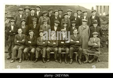 Carte postale originale et claire de l'époque des années 1920 d'un groupe de travailleurs de l'immobilier composé d'hommes de classe ouvrière portant des costumes, des casquettes et des bottes plates, et de jeunes apprentis/fouets, ainsi que de gestionnaires, d'employés de bureau, de garde-chasse (portant des chaussettes épaisses en laine). Landes derrière et balustrade de pierre, peut-être les travailleurs de succession. Beaucoup de caractères. ROYAUME-UNI Banque D'Images