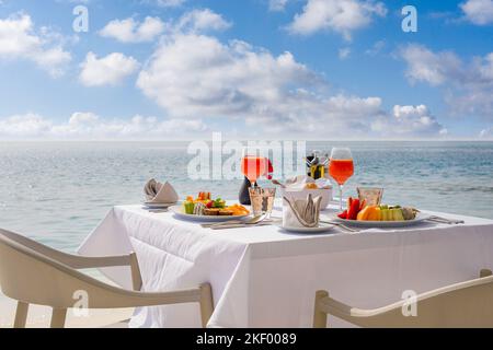 Table de petit déjeuner de luxe avec nourriture pour deux avec belle vue sur la mer tropicale. Vacances d'été le matin en couple et concept de vacances romantiques Banque D'Images
