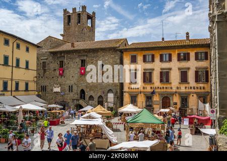 Étals du marché sur la Piazza Luca Signorelli avec Chiesa Evangelica 'dei Fratelli' en arrière-plan dans la ville de Cortona, en Toscane, en Italie Banque D'Images