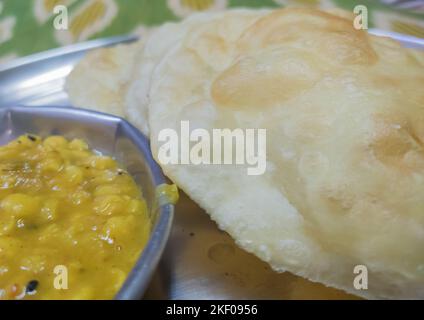 luchi ou puri servi sur une assiette en acier avec curry de lentilles. célèbre collation de petit déjeuner de l'inde. Banque D'Images