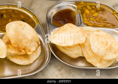 luchi ou puri servi sur une assiette en acier avec curry de pommes de terre et chutney. célèbre en-cas de petit déjeuner de l'inde. Banque D'Images