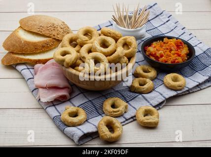 Taralli alla pugliese avec de l'huile d'olive extra vierge dans un bol en bois. En-cas italien traditionnel, taralli Banque D'Images