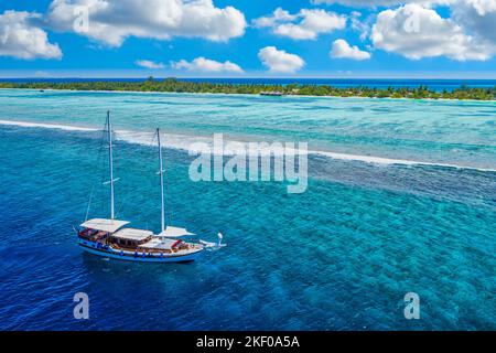 Petit yacht naviguant dans la mer tropicale au-dessus du récif de corail dans l'océan Indien lagon. Paysage exotique de l'île, vue aérienne, nature paisible pittoresque Banque D'Images