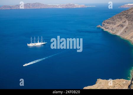 Bateau de croisière sur la mer bleu profond dans l'île de Santorini, la baie de Grèce avec de petits bateaux de transport. Vacances d'été, tourisme personnes en Méditerranée Banque D'Images