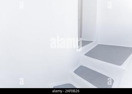 Escalier vide en pierre près du mur blanc, résumé à proximité de l'île de Santorini, Grèce. Architecture blanche avec marches grises. Détail minimal du bâtiment Banque D'Images