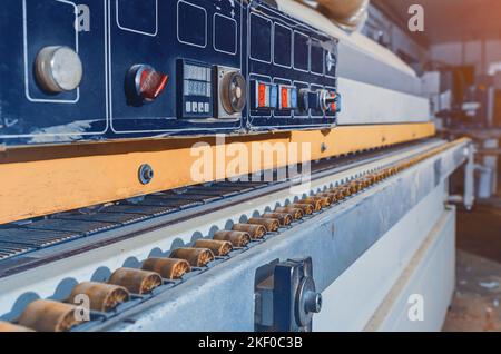 Partie en bois sur une machine à bandes de chant. Machine à travailler le bois dans un atelier de menuisier Banque D'Images