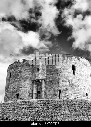 Une ancienne tour du 13th siècle est située sur un remblai de gazon. Une main courante surplombe le bâtiment et un ciel avec des nuages est au-dessus. Banque D'Images