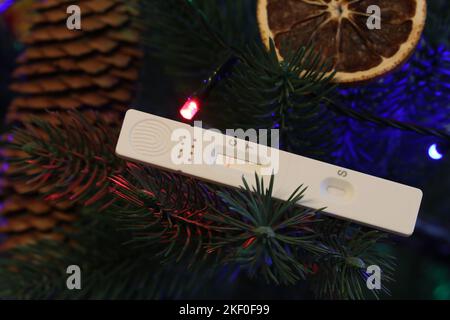 Auto-test rapide de l'antigène avec un résultat négatif sur les branches d'un arbre de Noël. Un symbole d'empêcher la propagation du Covid-19 au cours des vacances Banque D'Images