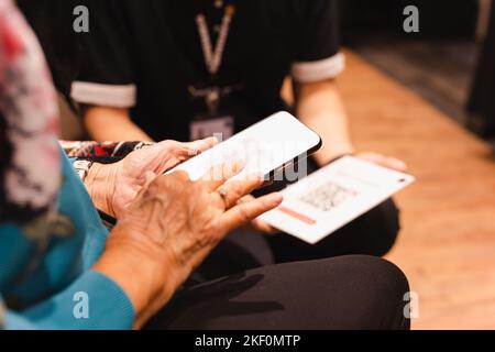 Femme âgée payant la facture à l'aide d'un téléphone intelligent scannez le code QR. Banque D'Images