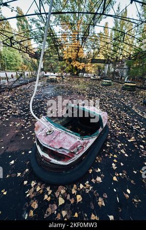 Sortie en voiture d'amusement abandonnée dans la ville fantôme de Pripyat dans la zone d'exclusion de Tchernobyl, Scooter aux couleurs de l'automne Banque D'Images