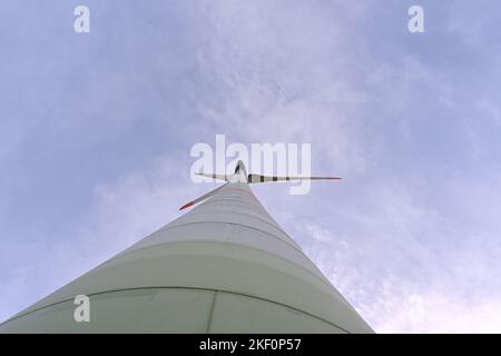 Vue à angle bas sur l'hélice et la colonne de l'éolienne sur terre contre le ciel bleu fournissant l'énergie renouvelable les besoins des habitants. Banque D'Images