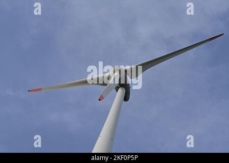 Vue détaillée sur l'hélice de l'éolienne sur terre contre ciel bleu fournissant de l'énergie renouvelable les besoins des habitants. Banque D'Images