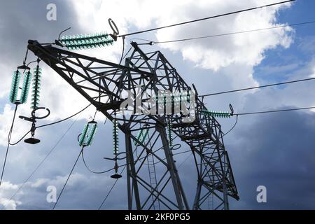 Montant d'alimentation avec isolateurs en verre électrique haute tension vert et câbles plafonniers utilisés pour la distribution d'électricité. Banque D'Images