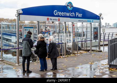 Les touristes consultent un horaire en attendant un Clipper sur la Tamise à Greenwich Pier, Londres, Royaume-Uni Banque D'Images