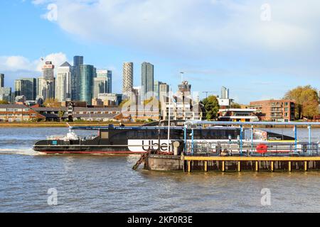 Un Clipper de la Tamise débarque à Greenwich Pier sur la Tamise, le quartier financier de Canary Wharf de l'autre côté de la rivière, Londres, Royaume-Uni Banque D'Images