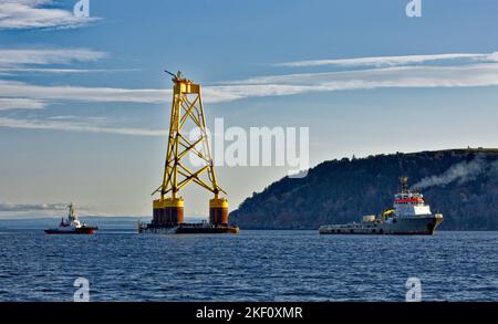 Cromarty Firth Nigg Scotland deux remorqueurs remorquant la base jaune d'une éolienne offshore dans le port Banque D'Images