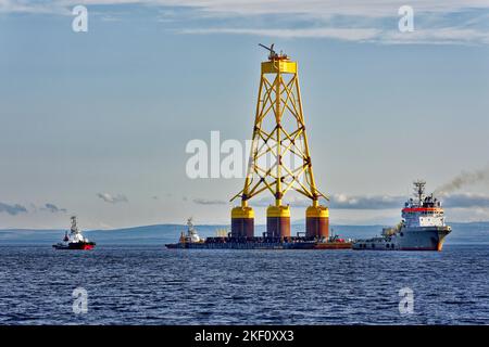 Cromarty Firth Scotland Nigg trois remorqueurs remorquant la base de la veste jaune d'une éolienne offshore Banque D'Images