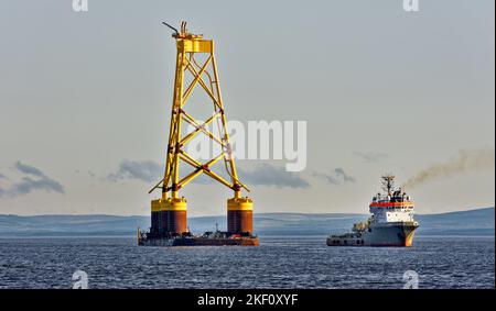Cromarty Firth Scotland navire Nigg remorquant la base jaune d'une éolienne offshore dans le port Banque D'Images