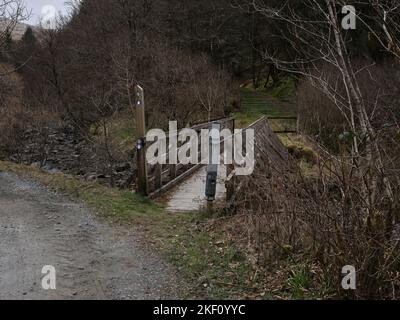 Sur le Loch Lomond et Cowal Way, une passerelle en bois au-dessus de la rivière Cur dans la forêt de Strachur par Balliemeanoch. Strachur. Argyll et Bute. Écosse Banque D'Images