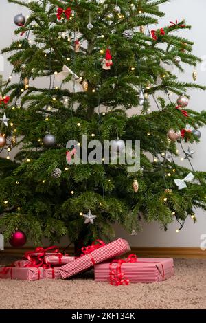 Cadeaux emballés sous l'arbre de noël. Présente sous le pin décoré. Banque D'Images