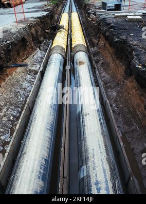 Réparation des communications urbaines. Remplacement des conduites d'eau, réparation et reconstruction des conduites de chauffage. Tuyau d'eau chaude et froide posé dans la tranchée. Banque D'Images