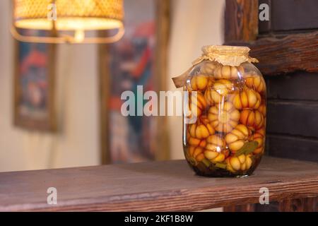 ail mariné dans un grand pot en verre sur une étagère en bois. Ail mariné savoureux Banque D'Images