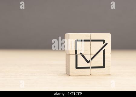 Conformité et réglementation de l'entreprise. Réalisation des objectifs et réussite de l'entreprise. Achèvement de la tâche. Cube en bois avec coche. Copier l'espace Banque D'Images