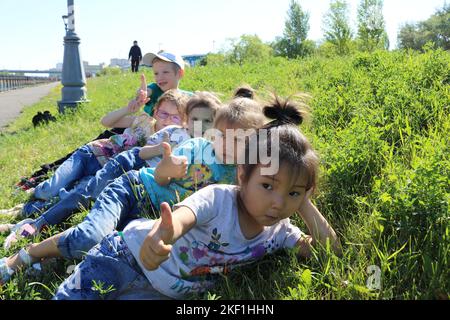 Un garçon et des filles aimant allongé sur une herbe verte, enjoant le temps Banque D'Images