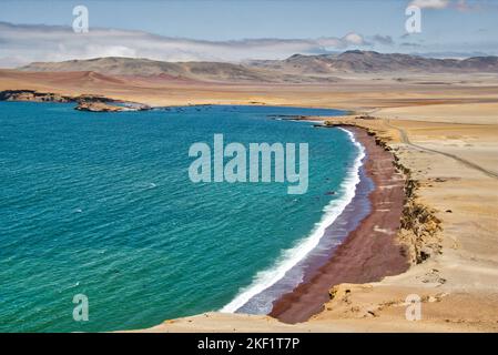 L'océan Pacifique rencontre le désert à Paracas, au Pérou, avec le fond de montagnes pittoresques et un ciel bleu Banque D'Images