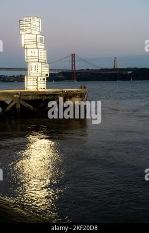 La sculpture de lumière publique Eschcultura de Luz (Sculpture de lumière) et le pont suspendu Ponte 25 de Abril dans le quartier de Belem à Lisbonne, Portugal. Banque D'Images