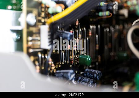 Un portrait axé sur un tas de résistances sur un circuit imprimé ou une carte électronique noir dans un périphérique ouvert entre d'autres composants soudés comme c Banque D'Images