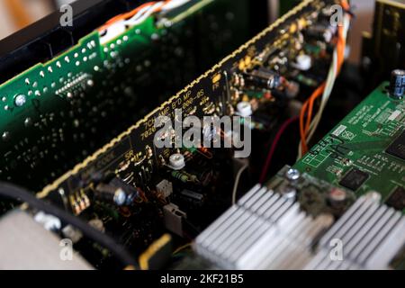 certaines cartes de circuit imprimé vertes et noires dans un dispositif électronique ouvert avec des composants électriques soudés sur eux, comme des résistances, des condensateurs et des inductances w Banque D'Images