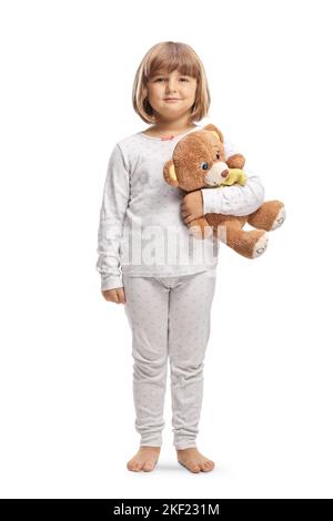 Portrait d'une petite fille en pyjama tenant un ours en peluche isolé sur fond blanc Banque D'Images