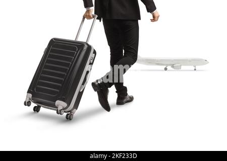 Vue arrière photo d'un homme tirant une valise et marchant vers un avion isolé sur fond blanc Banque D'Images