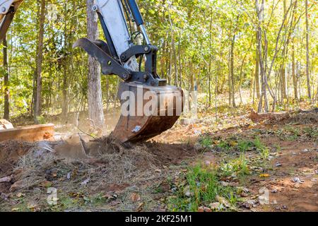 Les mini-chargeuses de tracteurs ont été utilisées pour dégager une grande surface de terre des racines en vue de la subdivision de développement du logement Banque D'Images