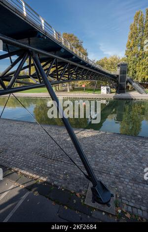 Réflexions sur le canal d'Ourcq d'un pont moderne au lever du soleil Banque D'Images