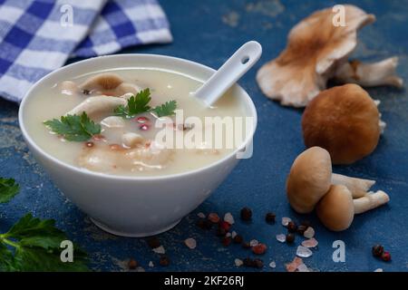 Soupe de champignons maison dans un bol blanc. Purée de soupe délicieuse aux champignons sauvages, aux poivrons et aux herbes. Banque D'Images