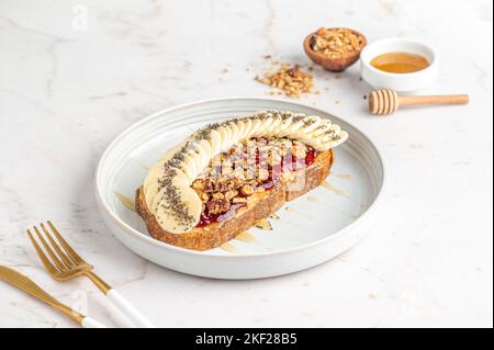 Un petit déjeuner toast avec des bananes servi sur une assiette blanche Banque D'Images