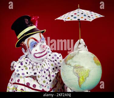1960S CLOWN DE CIRQUE PORTANT UN COSTUME À POIS TENANT UN PETIT PARAPLUIE DE PROTECTION SUR LE GLOBE TERRESTRE REGARDANT LA CAMÉRA - KC2783 HAR001 HARS ENTERTAINMENT CLOWNS PROTECTEURS OEIL CONTACT OBJECTIFS DOT PERFORMING ARTS HUMOUR AVENTURE ENVIRONNEMENT INTERPRÈTE STRATÉGIE DE PROTECTION POLKA MAQUILLAGE COMIQUE ENTERTAINER OCCUPATIONS WHITEFACE CONCEPTUEL POLKA DOT CLOWN WHITE COMEDY JESTER SUPPORT TINY EARTH DAY TOP HAT IDIOT HAR001 DÉMODÉE Banque D'Images