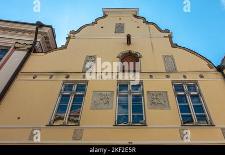 Estonie, Tallinn - 21 juillet 2022: Pikk 26, rue est la façade jaune historique de la Maison de la Confrérie des têtes noires avec plusieurs peintures murales en ciment gris Banque D'Images