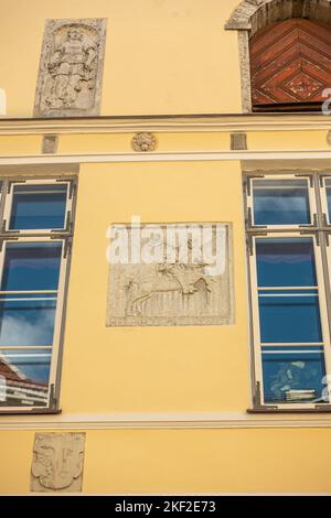 Estonie, Tallinn - 21 juillet 2022: Pikk 26, rue est la façade jaune historique de la Maison de la Confrérie des têtes noires avec couple murale de ciment gris Banque D'Images