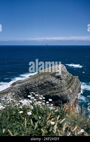 Des mouettes solitaire survolant calmement les grandes rochers des falaises à côté des fortes vagues de la mer Cantabrique, asturies, espagne Banque D'Images