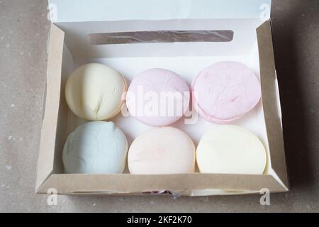Six guimauves colorées faites à la main dans une boîte en carton sur la table Banque D'Images