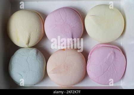 Six guimauves colorées faites à la main dans une boîte en carton sur la table Banque D'Images