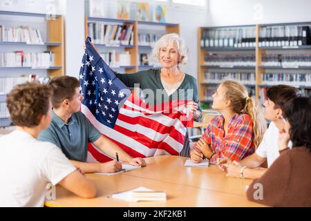 L'enseignante mature montre les jeunes enfants le drapeau national des États-Unis Banque D'Images