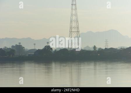 De Thaïlande, un paysage du Mékong avec des bâtiments, des infrastructures, des pylônes d'électricité et des montagnes au Laos. Banque D'Images