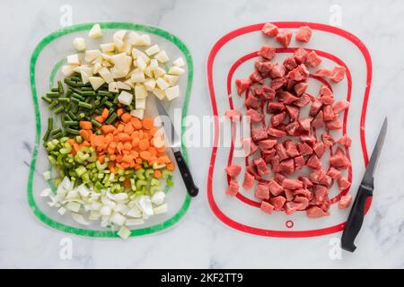 Le bœuf haché ragoût les ingrédients sur différents tapis pour éviter la contamination croisée. Banque D'Images